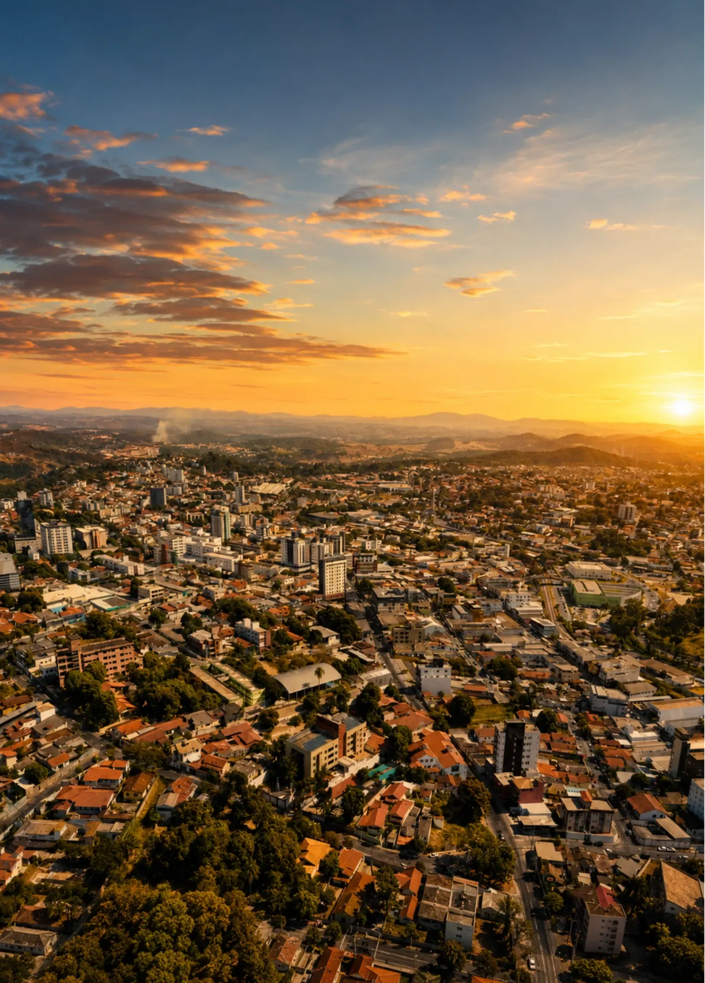 Betim vista do alto ao pôr do sol, com a malha urbana se estendendo até o horizonte