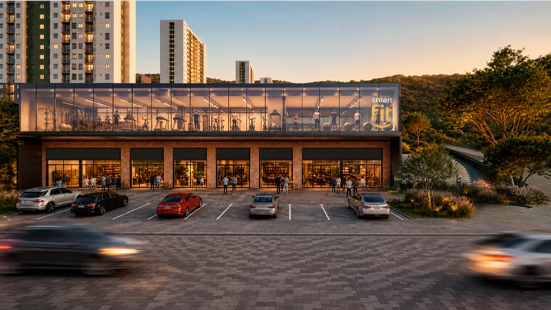 Edifício comercial da centralidade com estacionamento à frente e vegetação ao fundo