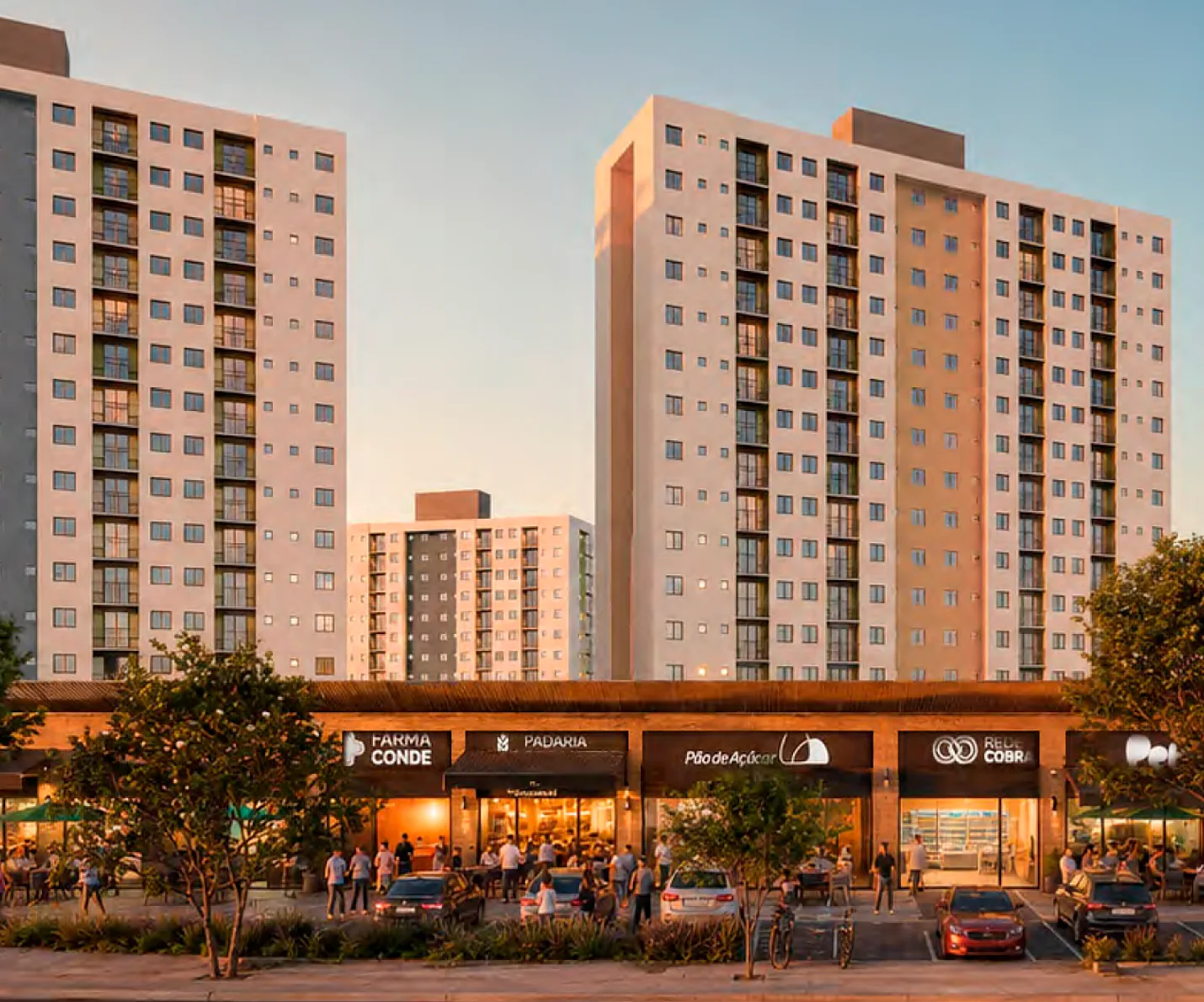 Torres residenciais vistas da avenida no entardecer, com comércio no térreo