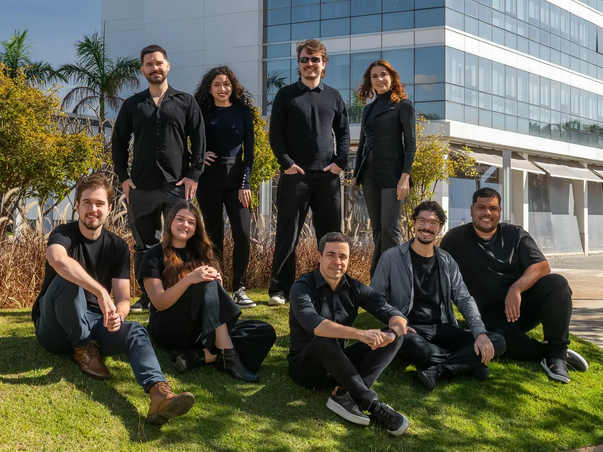 Equipe da Forma Garden Arquitetura Paisagística reunida no gramado, diante de um prédio de escritórios